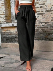 Black linen palazzo trousers with drawstring waist and wide legs.