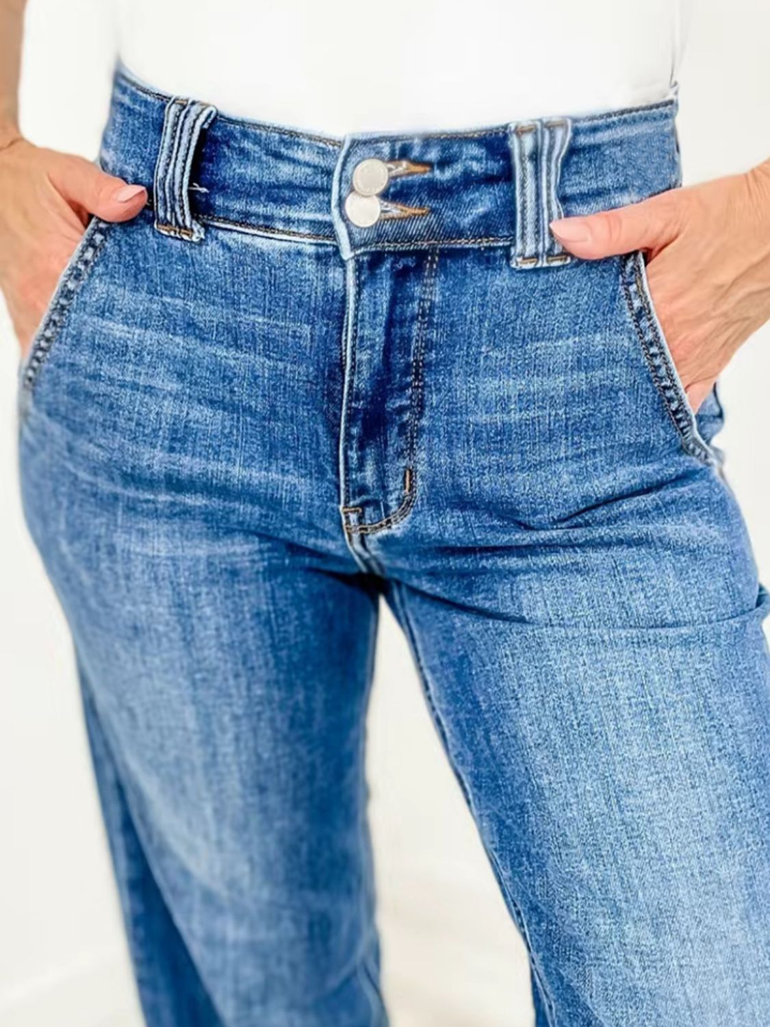 Medium wash denim jeans with wide leg and utility pockets.