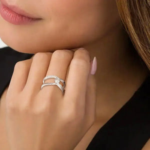Silver intertwined pavé band ring with sparkling stones on a hand.