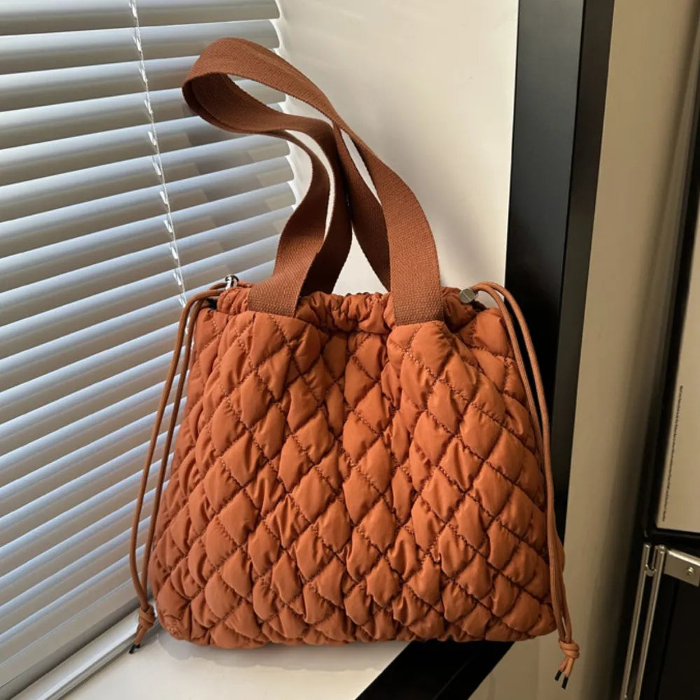 Quilted drawstring carryall handbag in Terracotta with diamond pattern and dual straps.