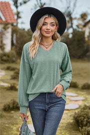 Sage textured cable knit v-neck sweater with long sleeves and a relaxed fit.
