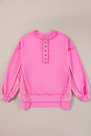 Fuchsia pink sweatshirt with button henley neckline and sequin side panels.
