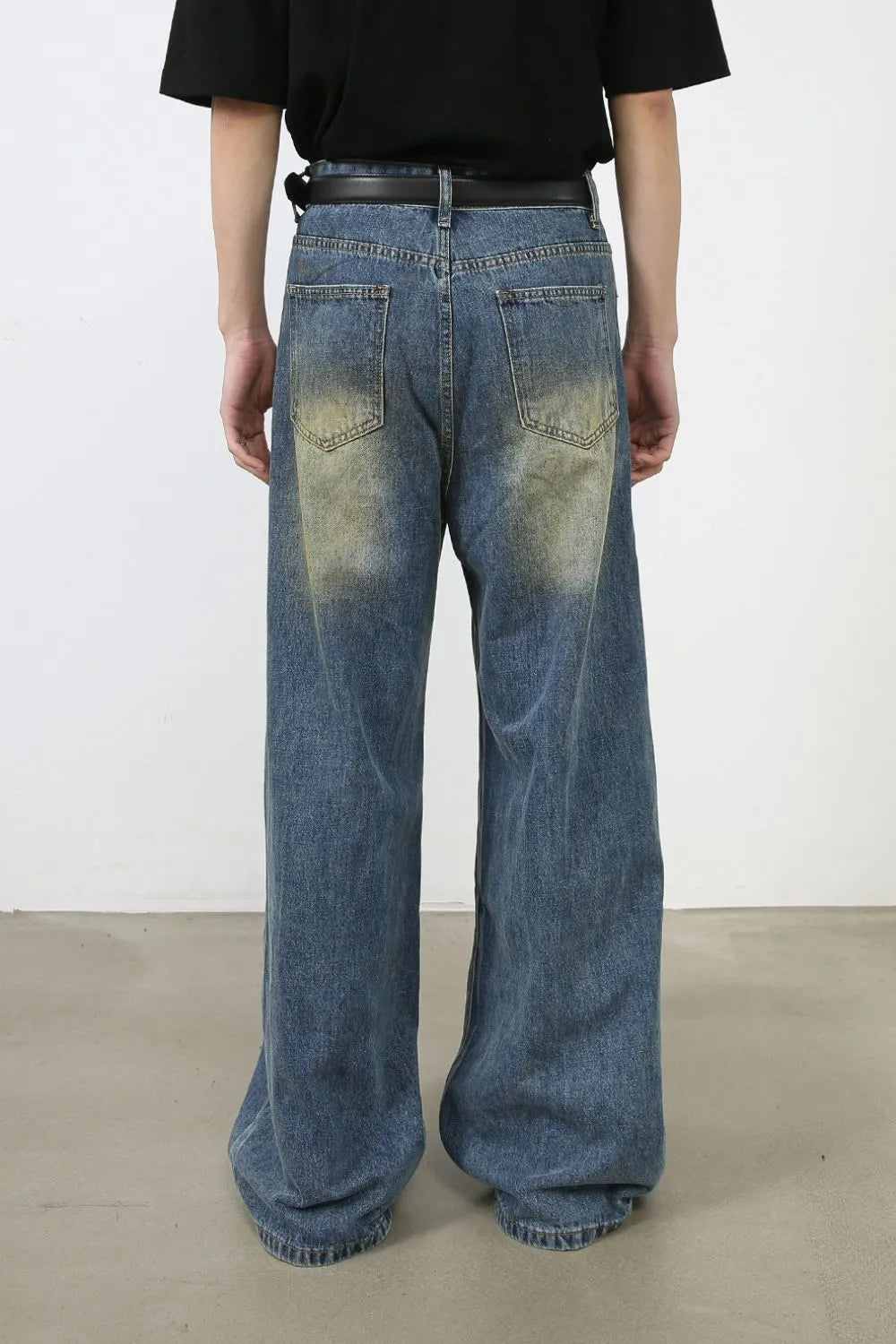 Faded patchwork denim palazzo trousers in medium wash, featuring a wide leg and distressed details.