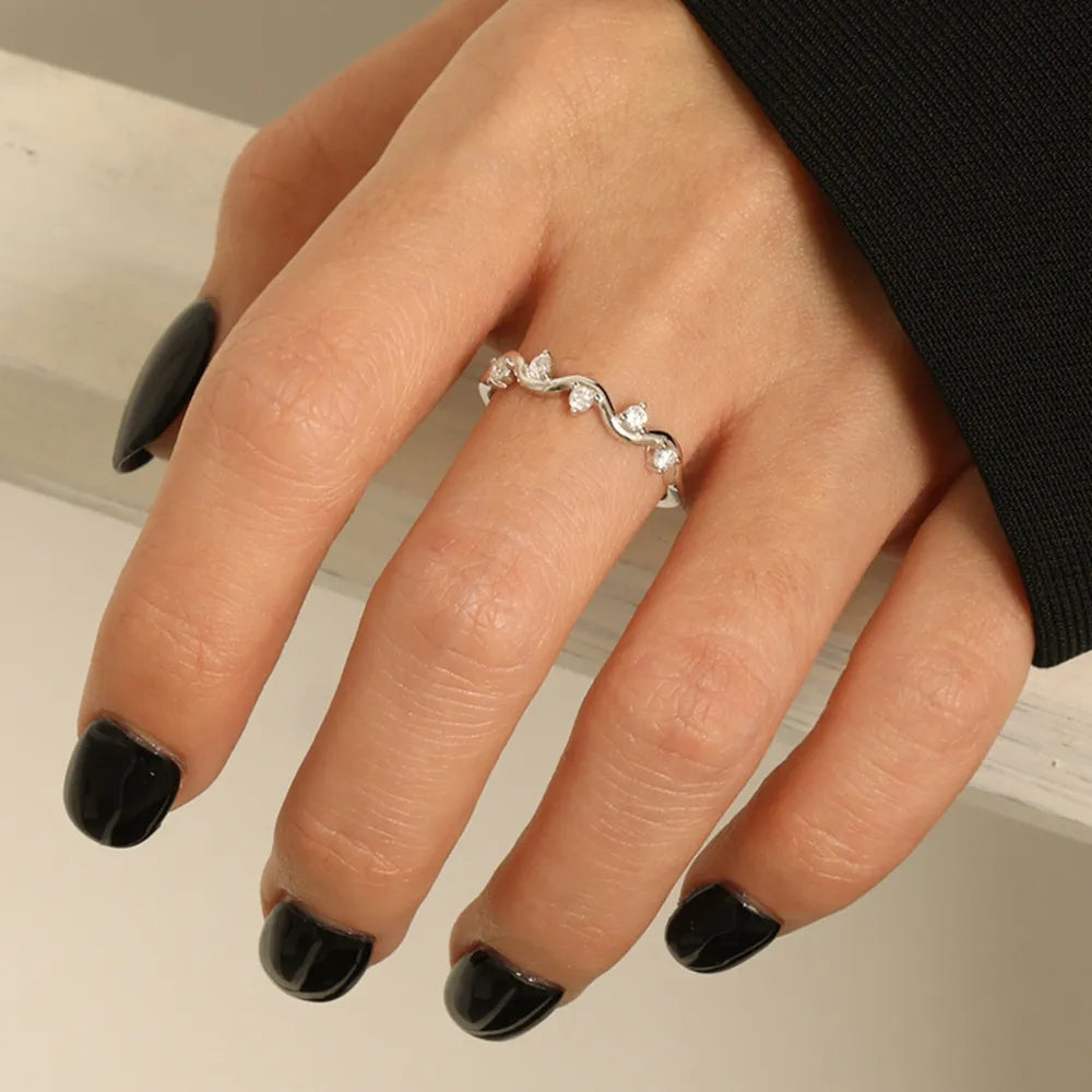 Silver band ring with wavy design and small clear stones