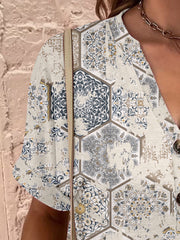 Bohemian tapestry print henley blouse with short sleeves and button detail.
