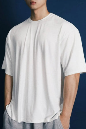 Oversized white crew neck t-shirt with a modern silhouette and short sleeves.