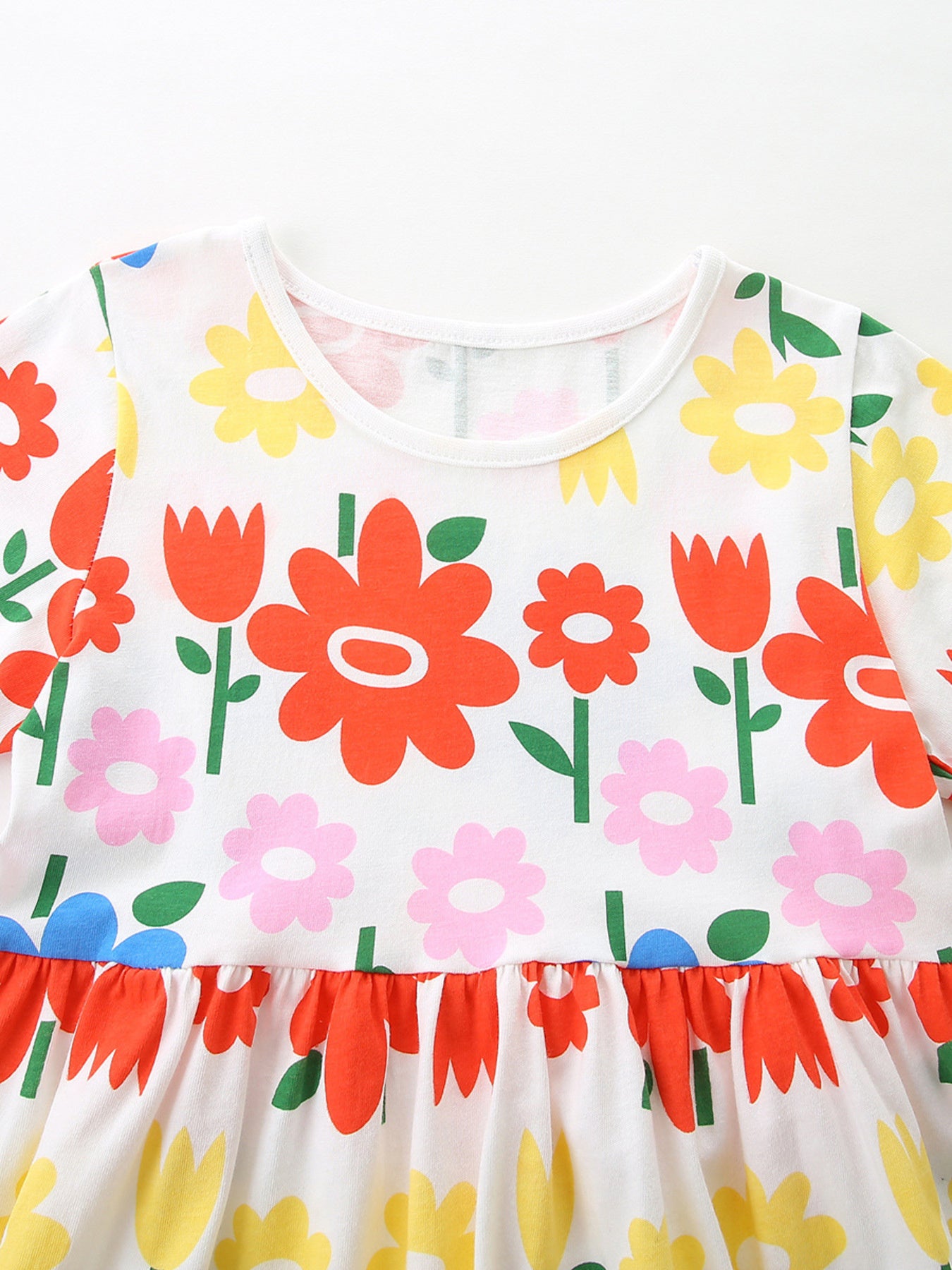 Toddler cotton dress with a whimsical floral print, ruffled hem, and crew neck.