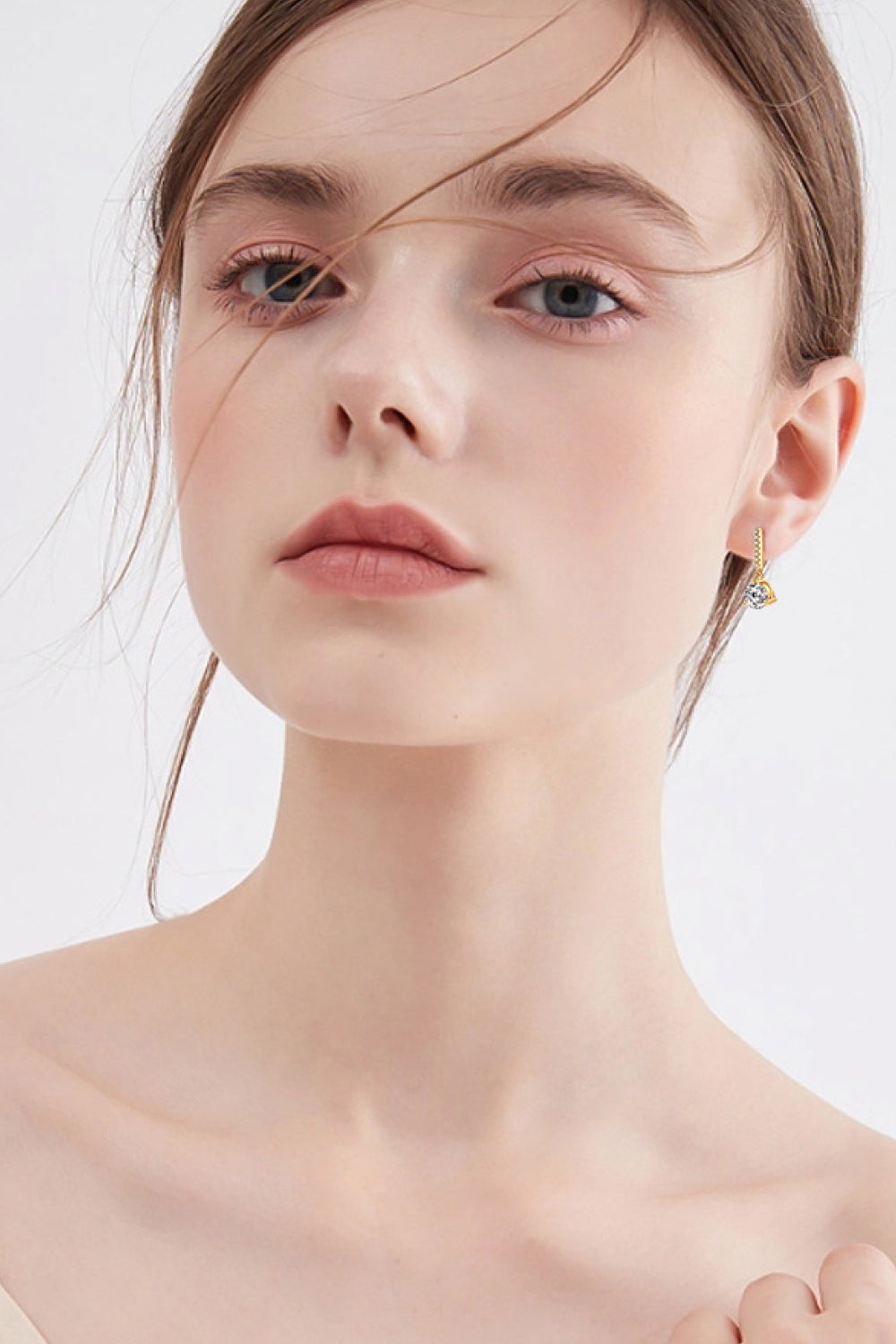 Gold drop earrings with clear prism pendant, delicate chain detail.