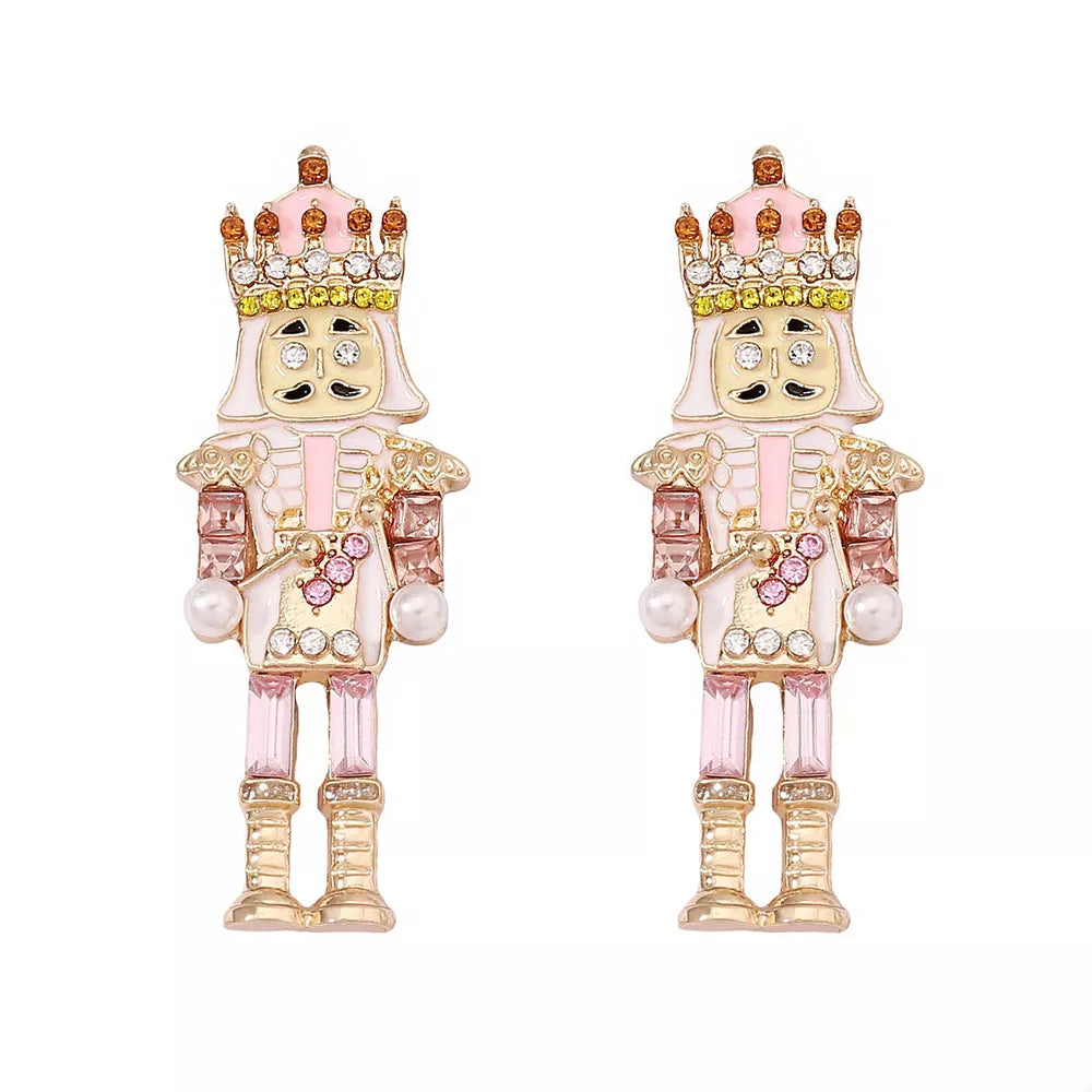 Blush pink nutcracker dangle earrings with crown and pearl details.