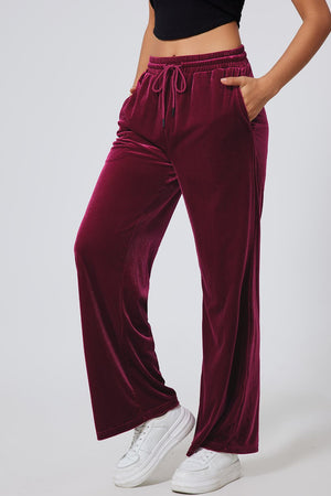 Burgundy velvet lounge pants with drawstring waist and wide legs.