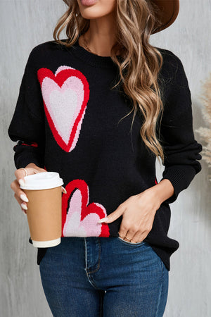 Black intarsia knit sweater with pink and red heart motif, crew neck, long sleeves.