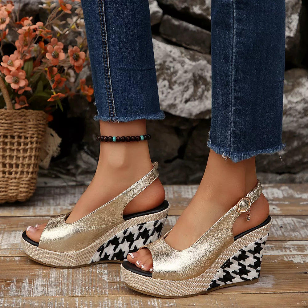 Gold open-toe wedge sandals with decorative buckle and houndstooth pattern wedge.