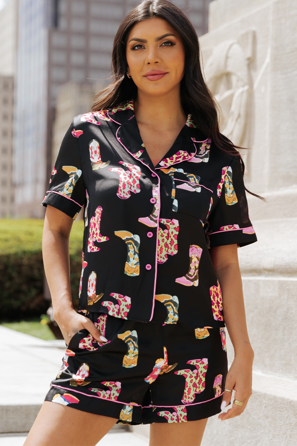 Black silk pajama set with colorful boot print and pink piping.