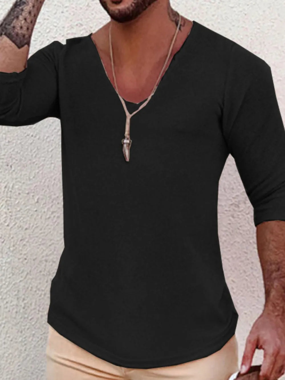 Black knit top with deep V-neck and 3/4 sleeves, textured fabric detail.