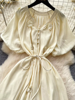 Apricot floral tie-waist maxi dress with puff sleeves and smocked neckline.