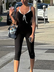 Black lace trim capri romper with tie-front neckline and white lace trim.
