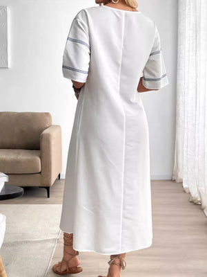 White maxi dress with blue stripe detail on sleeves and pockets.