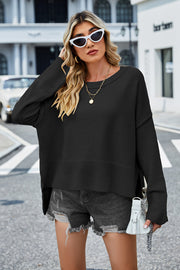 Black acrylic knit sweater with flared sleeves and slit hem detail.