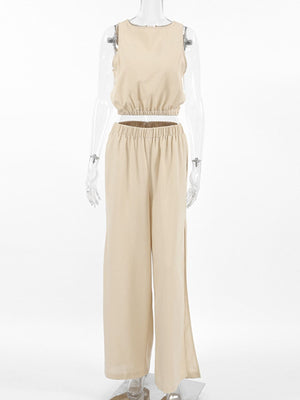 Sleeveless crew neck crop top and wide-leg pants set in tan cotton with elastic waist and side slits.