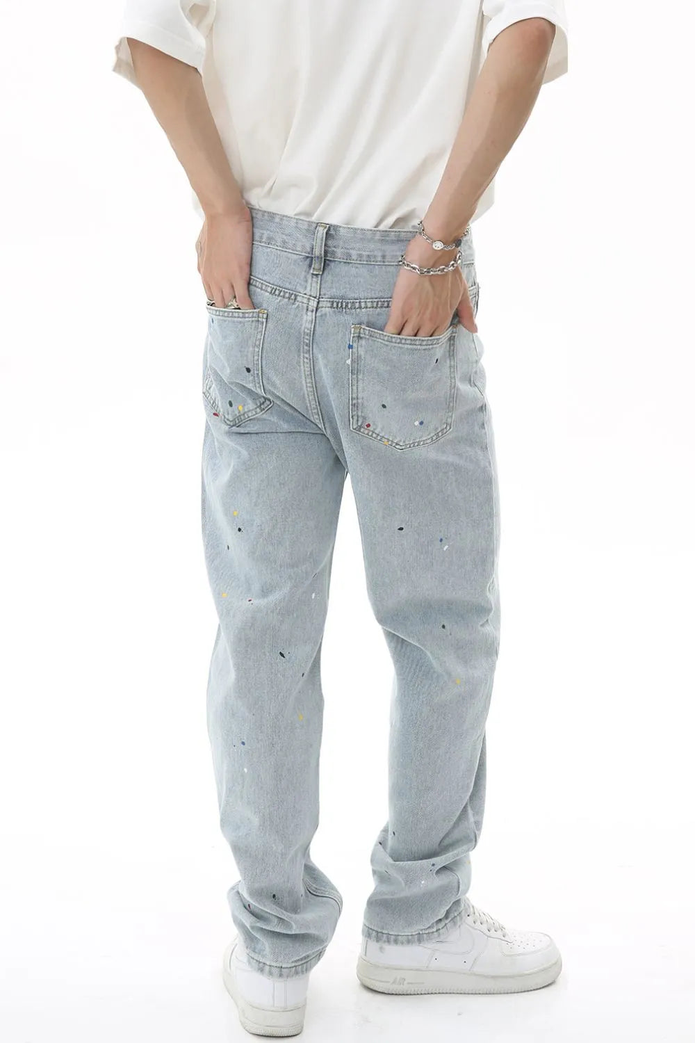 Light wash denim slouch trousers with paint splatter detail.