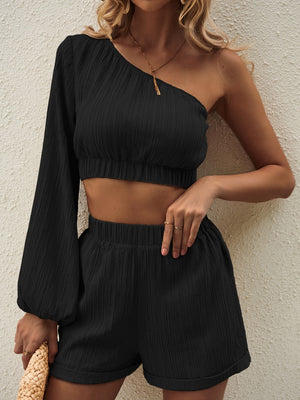 Black textured one-shoulder crop top with long balloon sleeve and matching high-waisted shorts set.