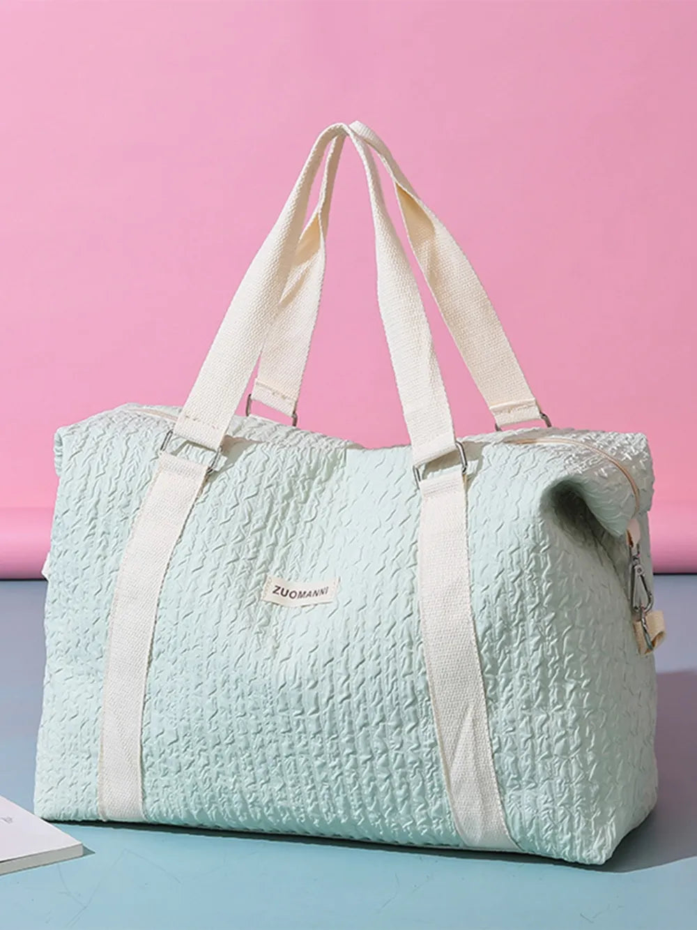 Light green waffle-weave weekend bag with white straps and silver hardware.