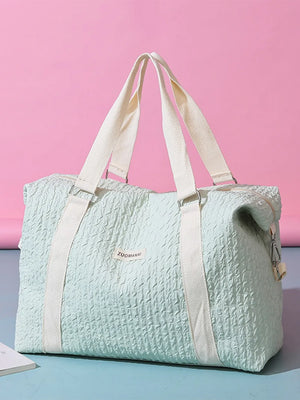 Light green waffle-weave weekend bag with white straps and silver hardware.