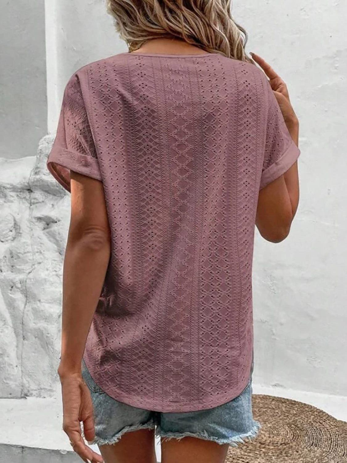Eyelet V-neck tunic top in pink purple with short sleeves and a textured pattern.