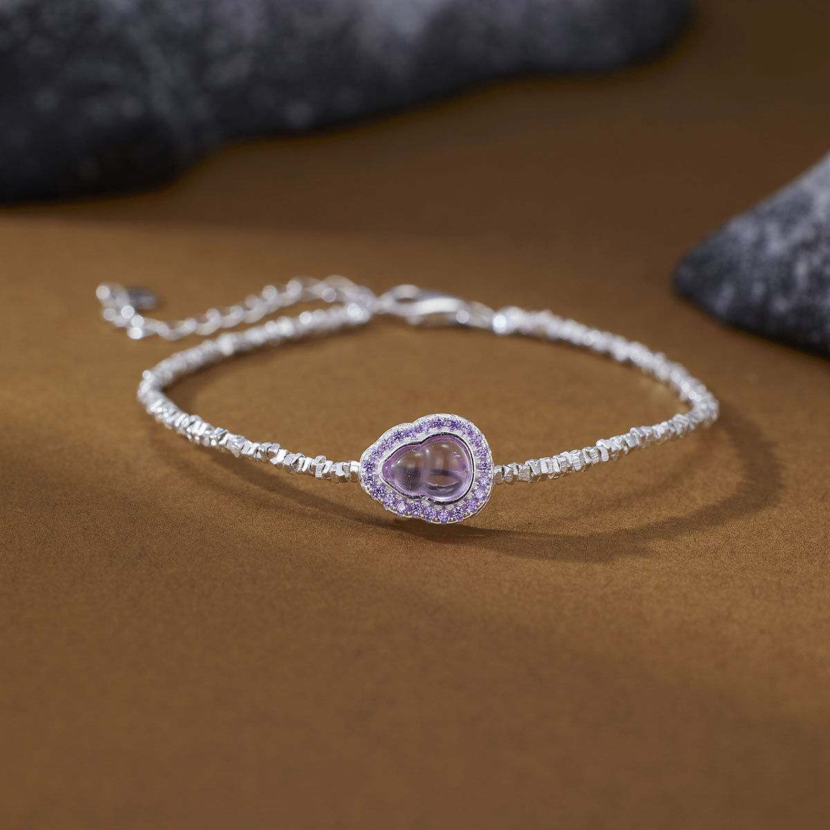Delicate silver bracelet with a purple gourd charm and crystal accents.