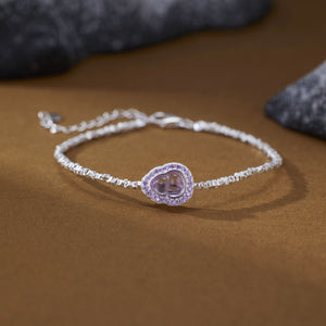 Delicate silver bracelet with a purple gourd charm and crystal accents.