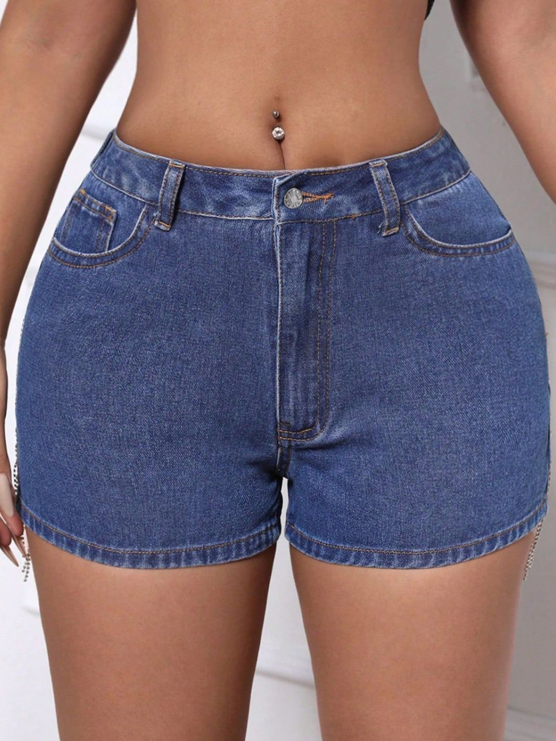 Medium wash denim shorts with crystal fringe detail on the sides.