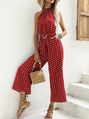 Red polka dot halter romper with belted waist and wide legs.
