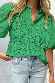 Green eyelet puff-sleeve blouse with stand collar and button front.