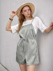 Sage pinstripe romper with adjustable drawstring waist, worn over a white tee.