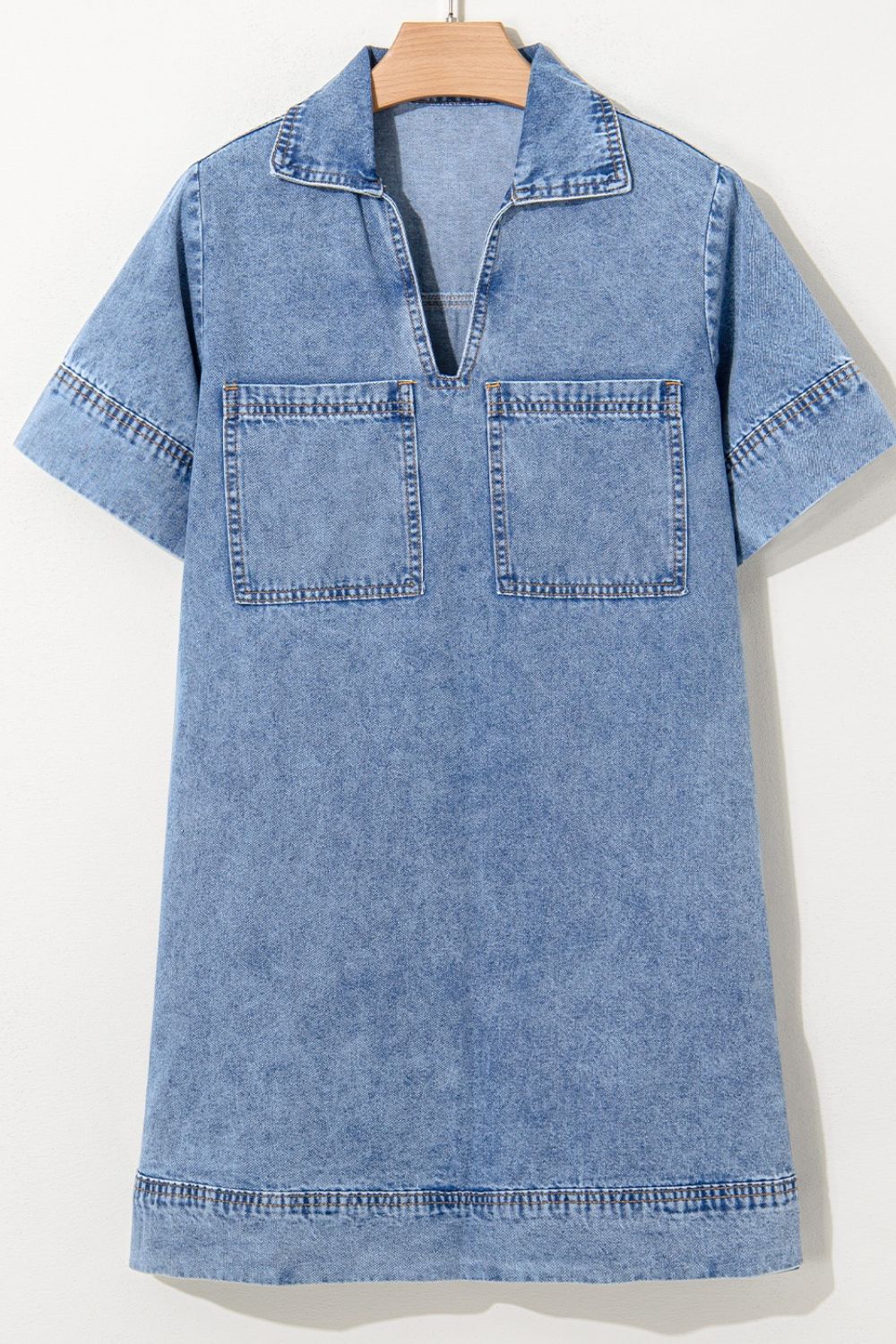 Light blue denim mini dress with collar, V-neck, short sleeves, and two chest pockets.