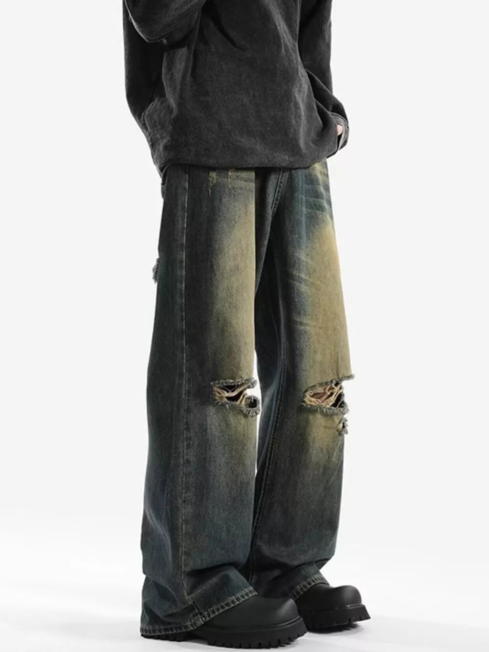 Men's vintage distressed wide-leg jeans in blue denim with ripped knees.