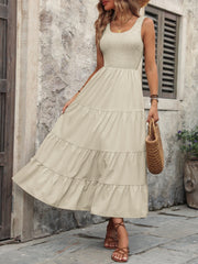 Beige smocked bodice tiered maxi dress with scoop neck and sleeveless design.