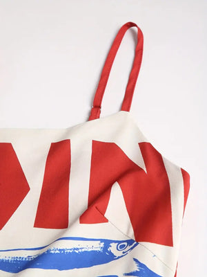 Spaghetti strap midi dress with bold red graphic print and blue fish detail.