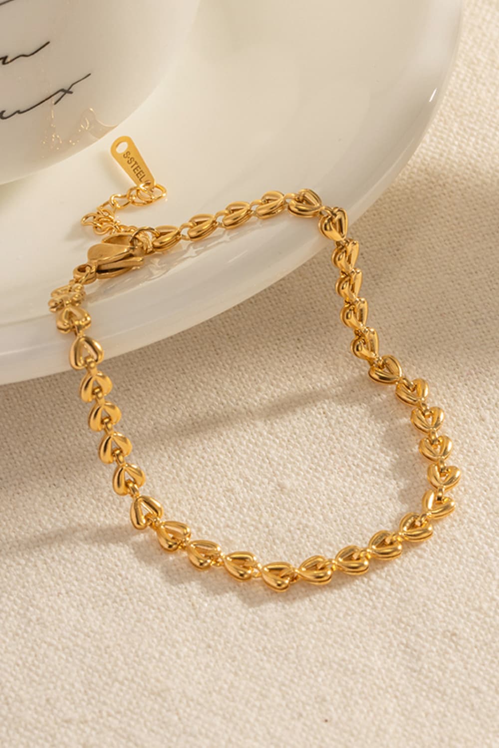 Gold heartbeat chain bracelet with lobster clasp and extension chain.