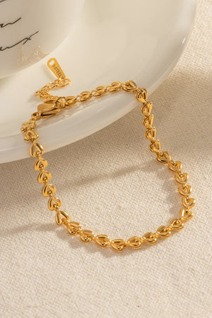 Gold heartbeat chain bracelet with lobster clasp and extension chain.