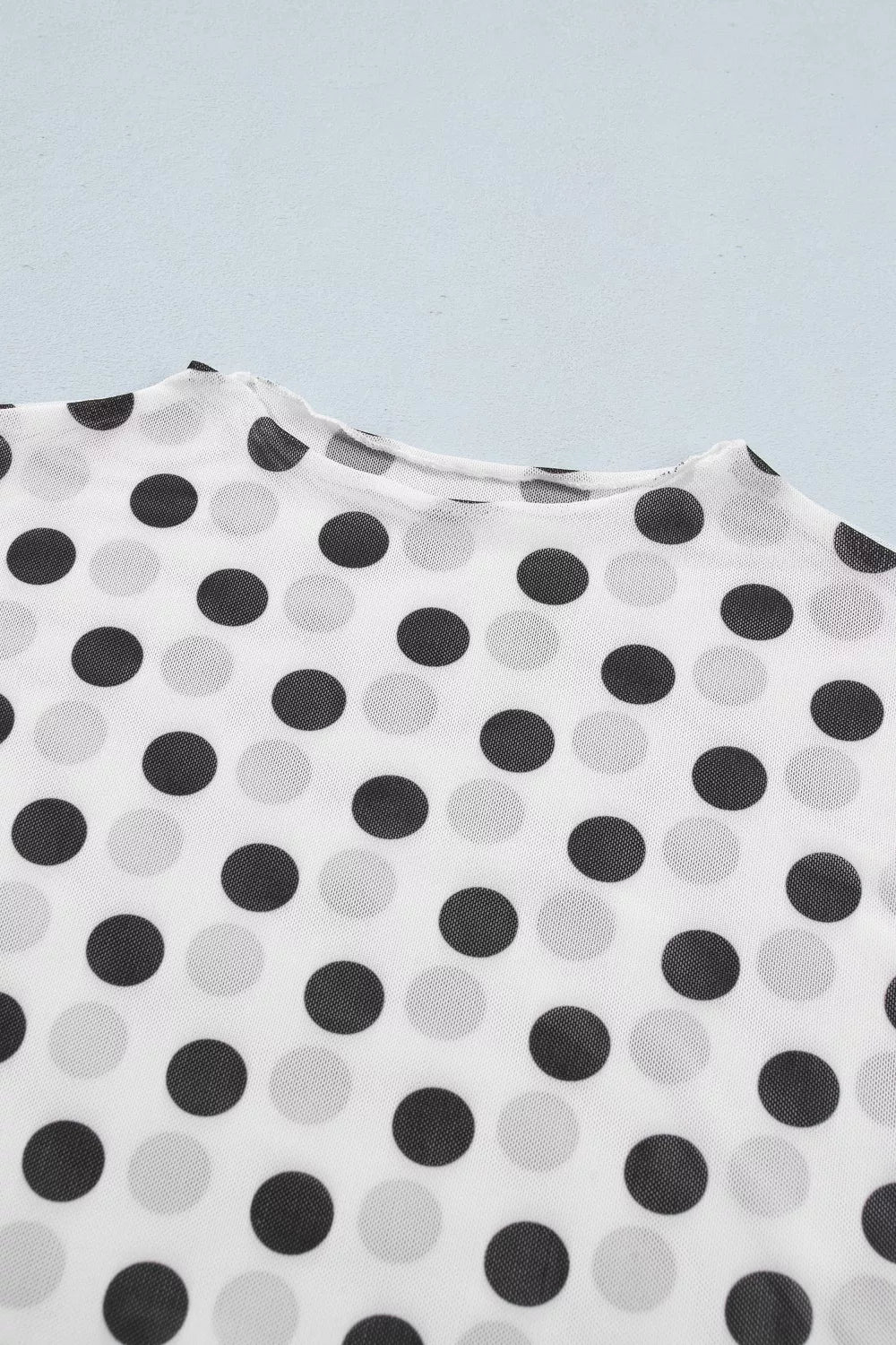 Chic polka dot mesh mock neck shirt in white with black and grey dots, sheer polyester fabric.