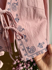 Pink tie-front top with paisley print and tie details.