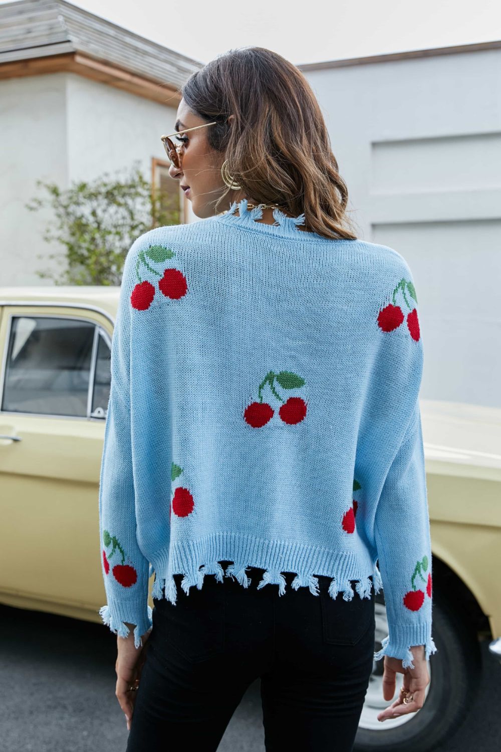 Blue knit sweater with frayed hem and cherry motif