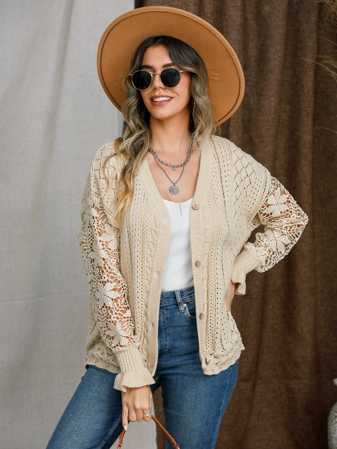 Tan knit cardigan with lace sleeves, button front, and cable knit details.