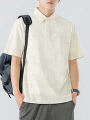 Cream cotton polo shirt with subtle texture and buttoned placket.