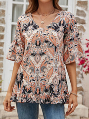 Paisley print v-neck blouse with ruffle hem and bell sleeves in tangerine and cream.