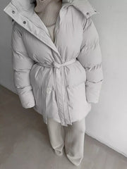 Ivory white belted puffer trench coat with hood and buttoned closure.
