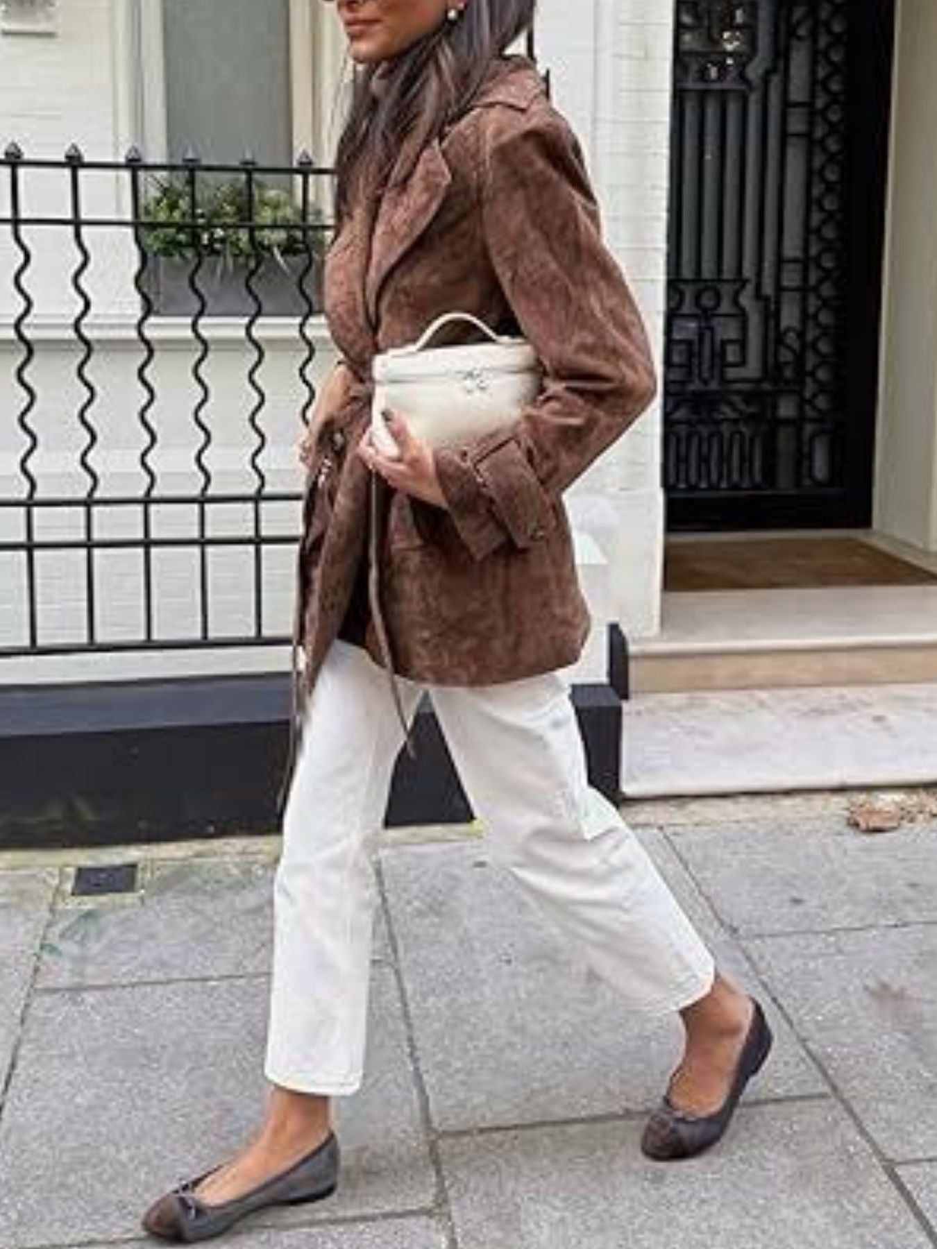 Dark brown belted double-breasted trench coat with cuffed sleeves, worn open over a turtleneck.