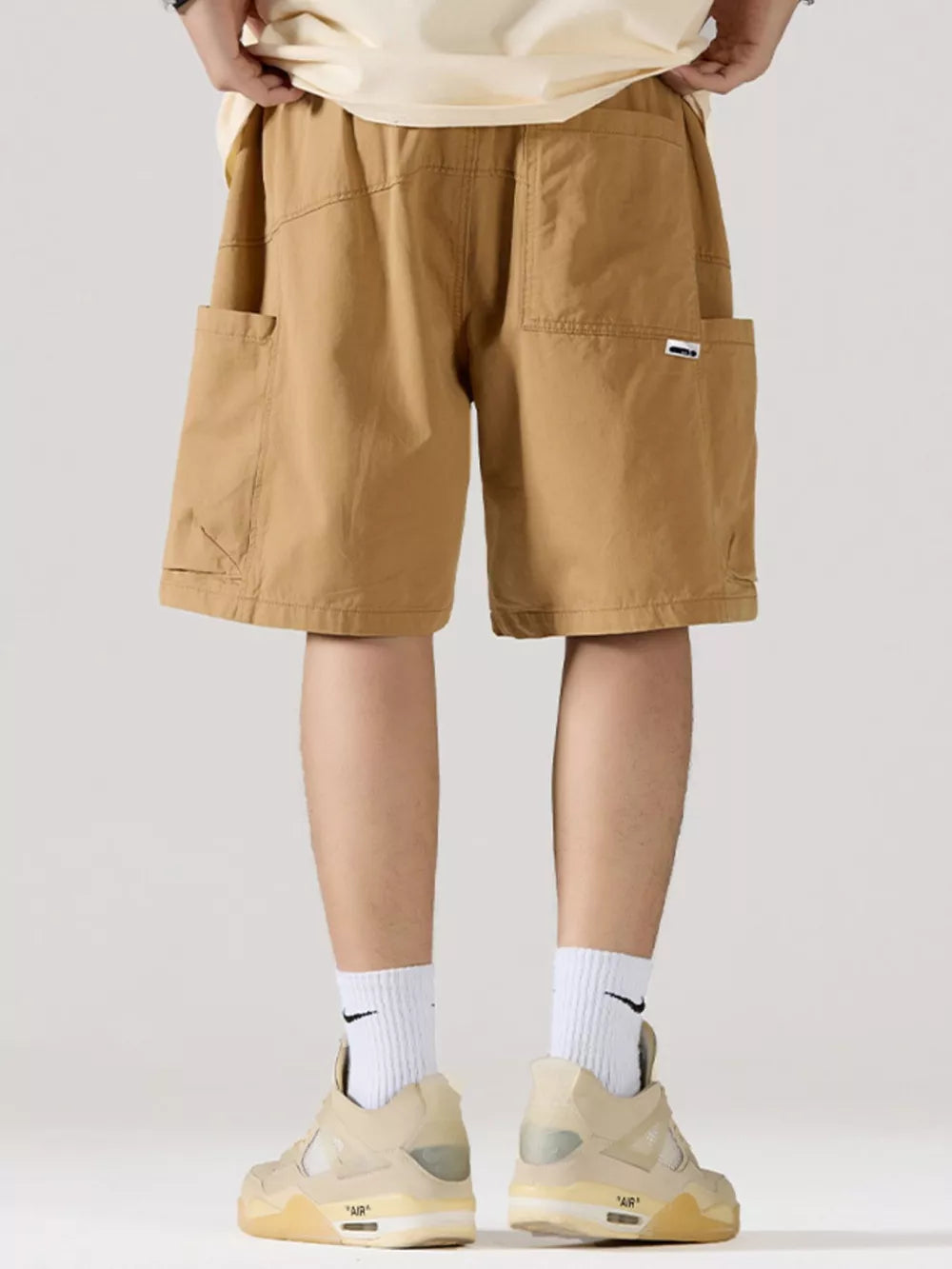 Khaki relaxed fit 100 cotton cargo shorts with adjustable drawstring and multiple pockets.