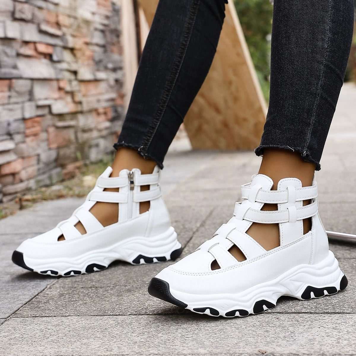 White chunky cutout platform sneakers with ankle straps and zipper detail.